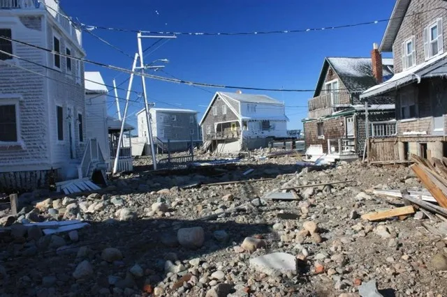 Wreckage of decks and boardwalks piled among stone on a Cedar Point road