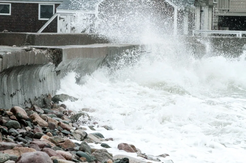 Storm surf breaking over the Scituate seawall in front of oceanfront homes